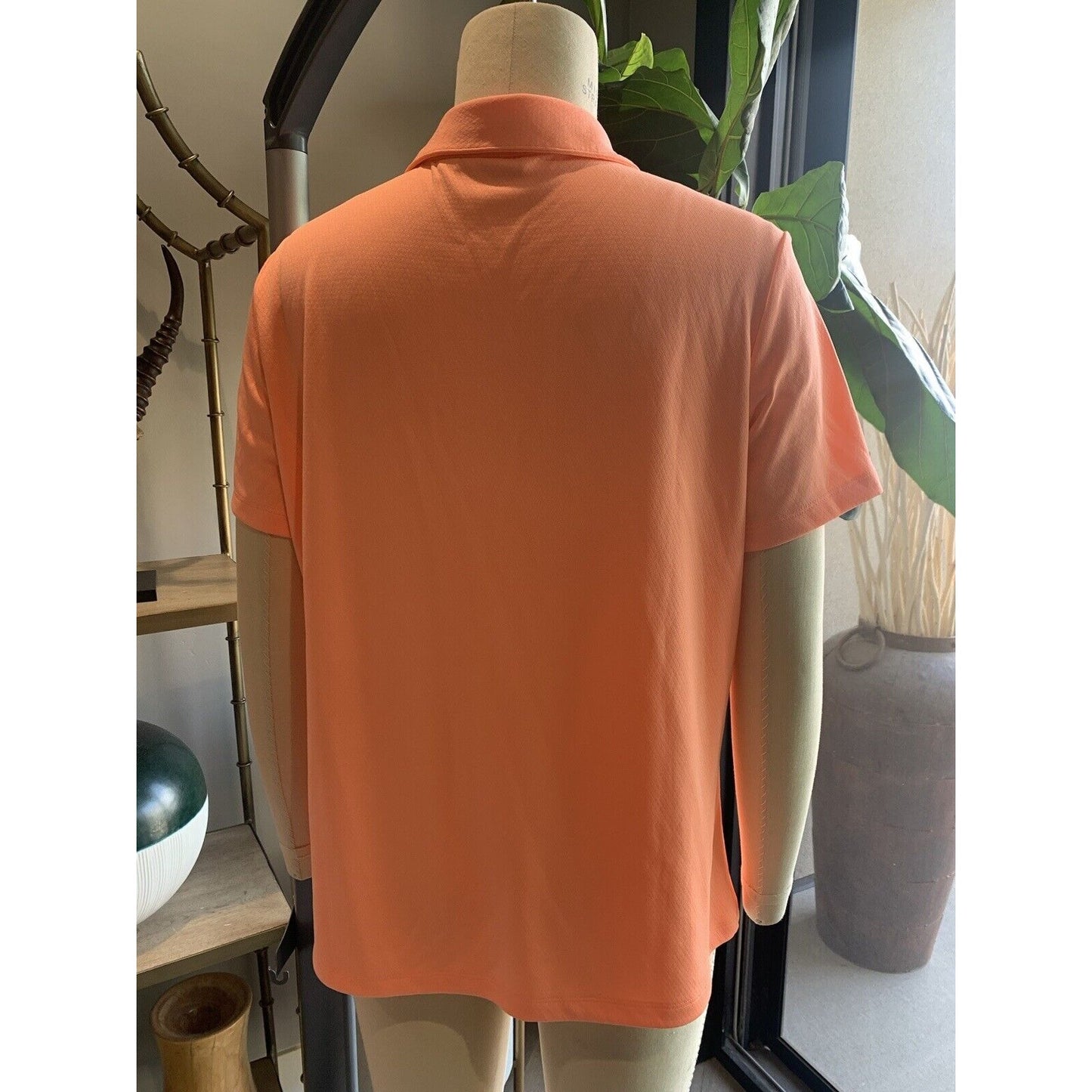 Rear View Of Women's Melon Colored Golf Shirt