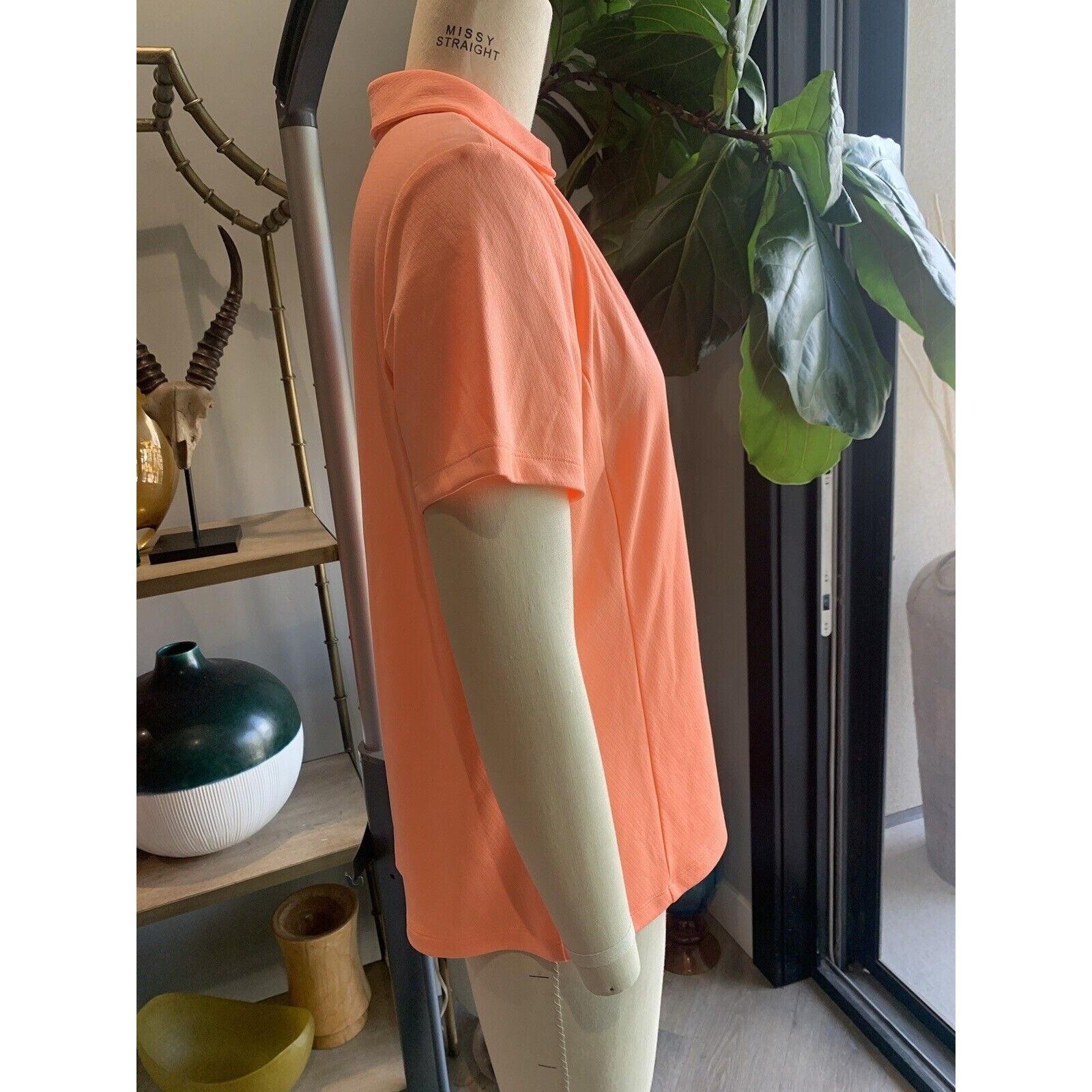 Side View Of Women's Melon Colored Golf Shirt