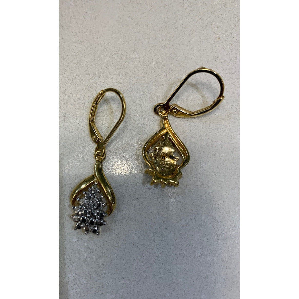 18 Karat Gold Over Sterling Silver Diamond Accent Cluster Earrings With The Back Of One Earring Showing On Gray Background